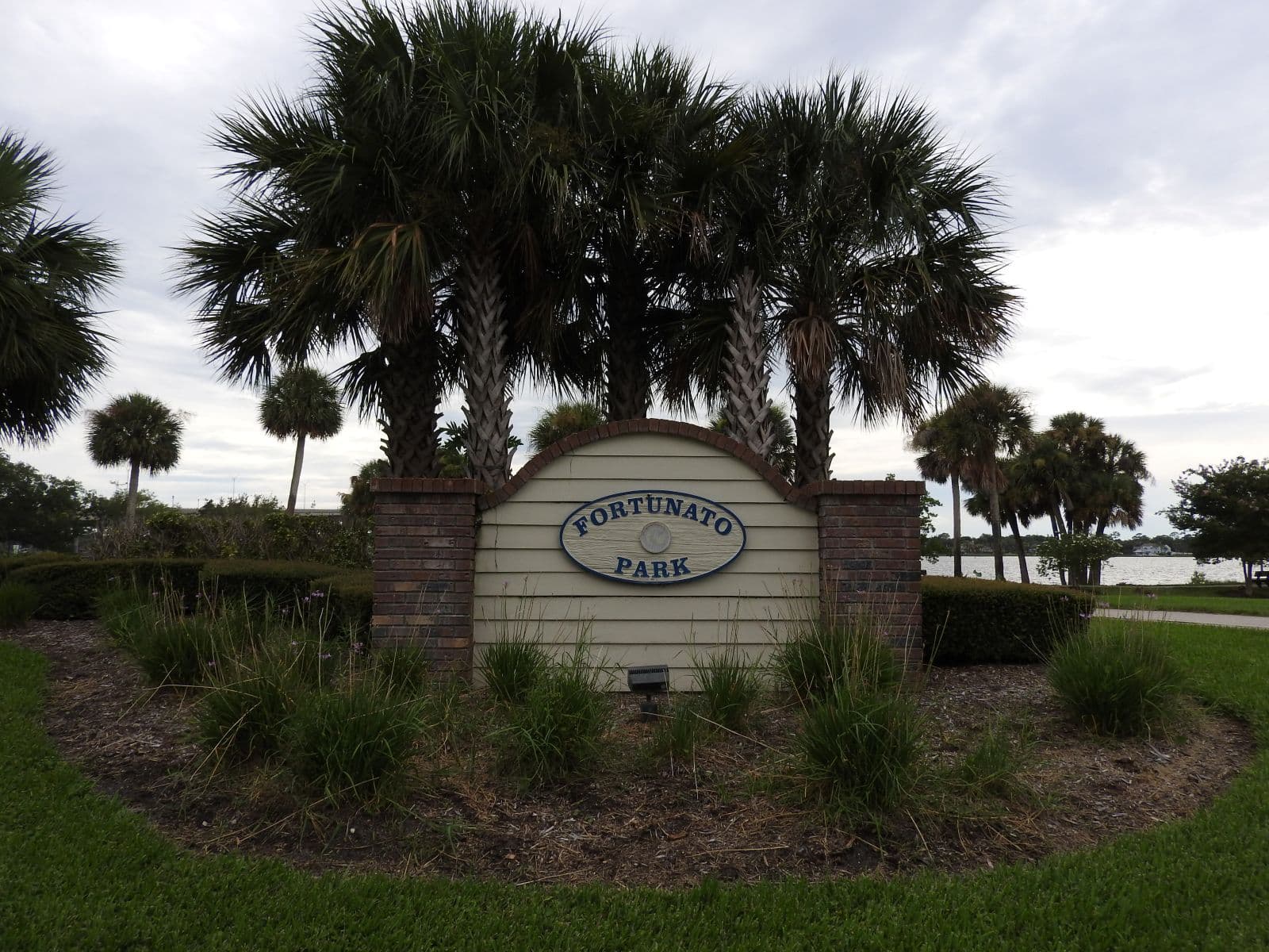 Fortunato Park entrance sign framed by palm trees near the Halifax River.