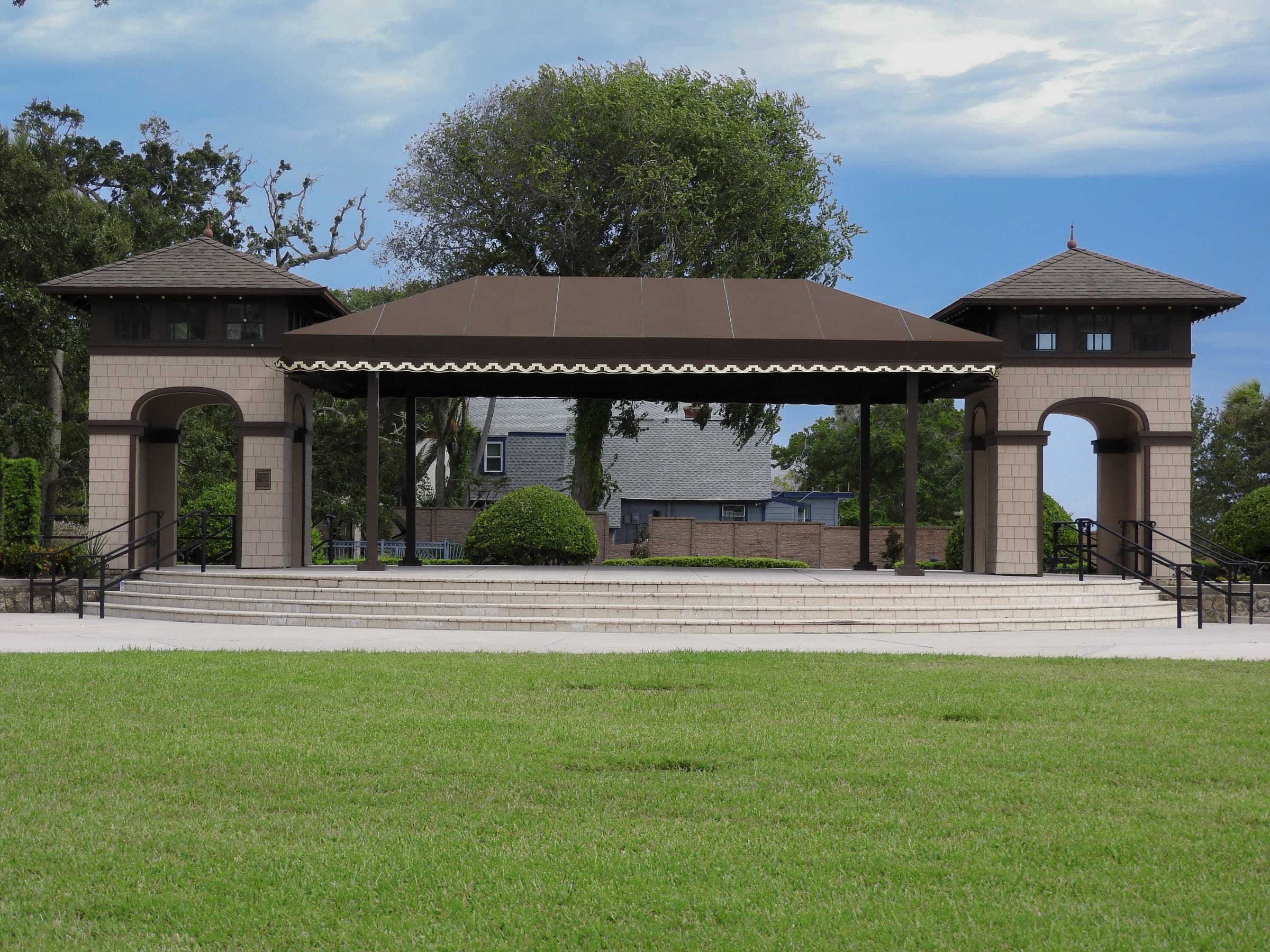 Rockefeller Gardens event pavilion viewed across an open green lawn.