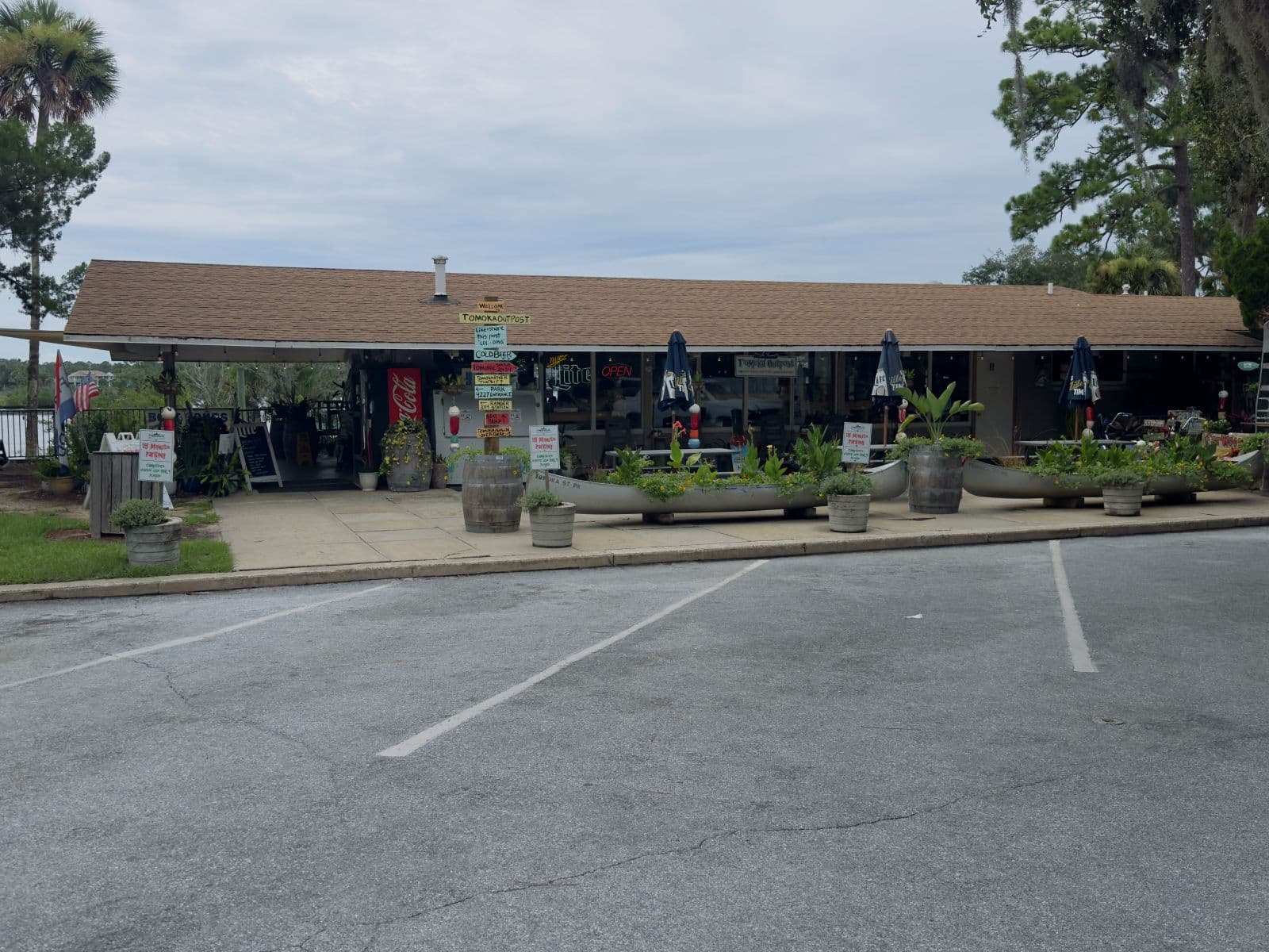Tomoka Outpost park store with canoe planters and visitor parking in front.